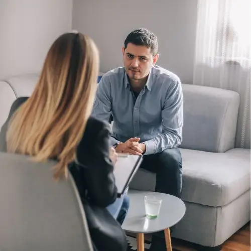 Assessor and employee discussing workplace needs and reasonable adjustments in a one-to-one meeting.